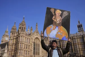 Artist Kaya Mar poses with his painting of US President Donald Trump in Westminster in London, Thursday, April 3, 2025. (AP Photo/Kirsty Wigglesworth)