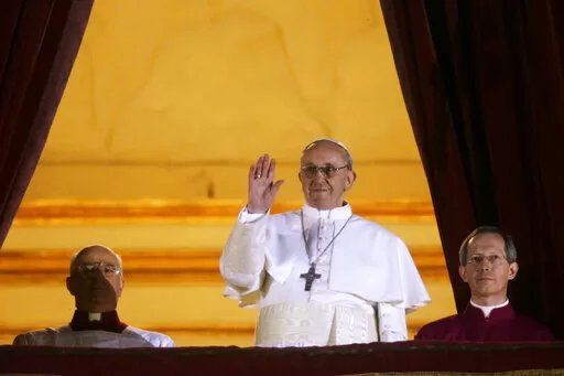 FILE –  Argentine Cardinal Jorge Bergoglio, who chose the name of Pope Francis, waves to the crowd from the central balcony of St. Peter’s Basilica after being elected 266th pontiff of the Roman Catholic Church, at the Vatican, Wednesday, March 13, 2013. (AP Photo/Gregorio Borgia, file)