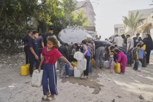 Palestinians collect water in jerrycans at a distribution point west of Gaza City, Sunday, May 11, 2025. (AP Photo/Jehad Alshrafi)