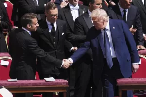 President Donald Trump, right, shakes hands with French President Emmanuel Macron, left, as Finland’s President Alexander Stubb, looks on, as they attend the funeral of Pope Francis in St. Peter’s Square at the Vatican, Saturday, April 26, 2025. (AP Photo/Evan Vucci)